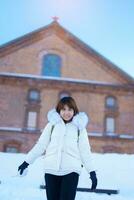 kvinna turist besöker i sapporo, resande i Tröja ser sapporo öl museum med snö i vinter- säsong. landmärke och populär för attraktioner i Hokkaido, japan. resa och semester begrepp foto