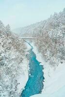 shirahige vattenfall med snö i vinter, biei flod strömma in i blå damm. landmärke och populär för attraktioner i Hokkaido, japan. resa och semester begrepp foto