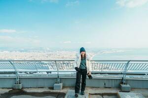 kvinna turist besöker i hakodate, resande i Tröja sightseeing se från hakodate berg med snö i vinter. landmärke och populär för attraktioner i Hokkaido, japan.resor och semester begrepp foto