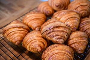 hemlagad croissant på rostfri stål grill och på trä bakgrund, bageri foto