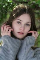 porträtt av generation z tonåring flicka med lång hår och Nej smink på naturlig bakgrund i skog foto