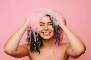 glad kvinna tvättning henne hår på rosa bakgrund. generera ai foto