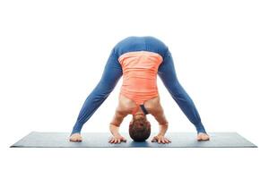 kvinna håller på med yoga asana prasarita padottanasana foto