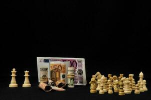 schack bitar och pengar på en svart bakgrund foto