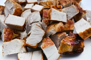 bitar av friterad fläsk kött på en vit tallrik. saftig och utsökt bitar av utegrill kött. foto