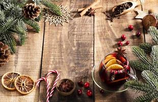 jul glögg med kryddor på ett rustikt träbord. foto
