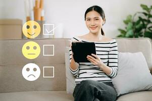 kund service utvärdering begrepp. kvinna visa ansikte leende uttryckssymbol visa på virtuell skärm från hand.ser på smart telefon, läsplatta och bärbar dator foto