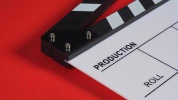 clapperboard eller filmskiffer på röd bakgrund. den används i videoproduktion och filmindustri. foto