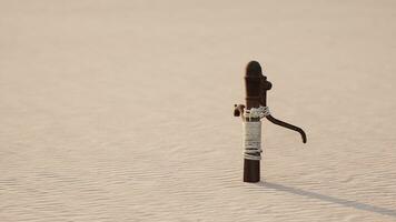 rostig gammal metall vatten pump på sand strand foto