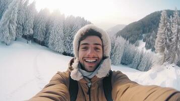 ai genererad ung man tar en selfie i en snöig berg landskap, bär vinter- kläder en beige täcka med en päls huva foto