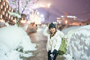 kvinna turist sightseeing i niseko stad med snö i vinter- säsong. landmärke och populär för attraktioner i Hokkaido, japan. resa och semester begrepp foto