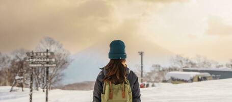 kvinna turist besöker i niseko, resande i Tröja sightseeing yotei berg med snö i vinter- säsong. landmärke och populär för attraktioner i Hokkaido, japan. resa och semester begrepp foto