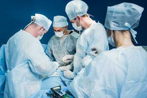 en i hög grad kvalificerad team av kirurger utför en komplex drift till ta bort en pankreas- cysta använder sig av medicinsk instrument foto