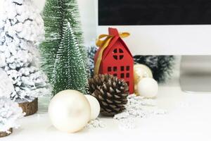 festlig scen är en skön jul träd Utsmyckad, med jul bollar, tall kottar, och en röd hus gåva låda bunden med gyllene band. jul attrapp med Plats för text. foto