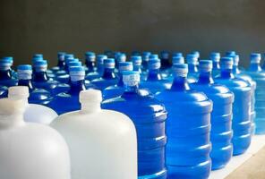 plast stor flaskor eller vit och blå liter av renades dricka vatten inuti de produktion linje. vatten dryck fabrik foto