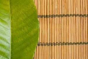 grön blad på bambu bordstablett foto