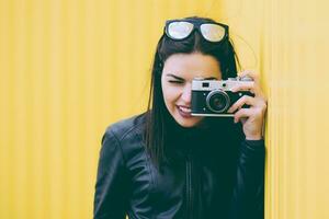 attraktiv flicka tar bilder med ett gammal kamera foto