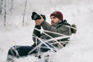 resande fotograf tar bilder i de vinter- skog foto