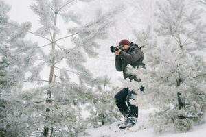 resande fotograf tar bilder i de vinter- skog foto
