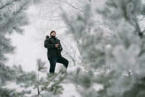 resande fotograf tar bilder i de vinter- skog foto