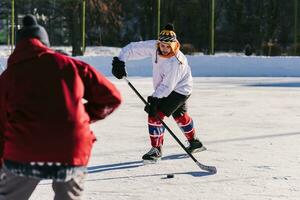 män spela hockey på de rink under de dag foto