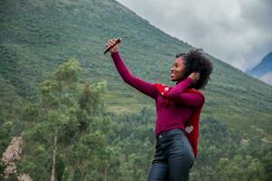 Söt leende afro flicka i svart byxor och röd Tröja håller på med en leva utsända Nästa till en vulkan foto