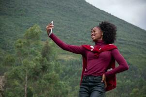 afro influencer flicka strömning på en bergssidan foto