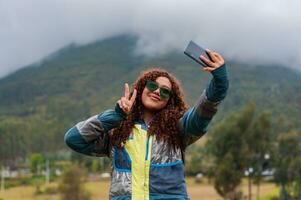 Tonårs lantlig turism influencer från ecuador skapande med hade för henne följare leende och framställning seger tecken med henne fingrar. foto