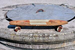 en skateboard är Sammanträde på topp av en betong blockera foto