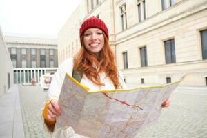 skön rödhårig kvinna, turist med stad Karta, utforskar sightseeing historisk landmärke, gående runt om gammal stad, leende lyckligt foto