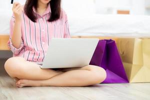närbild asiatisk kvinna som handlar online med bärbar dator. foto