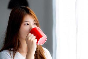 ung asiatisk kvinna med dricka en kopp kaffe. foto