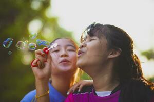 asiatisk tonåring spelar soppa bubbla med lycka foto