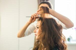 frisör håller på med hår stil för kvinna. begrepp av mode och skönhet foto
