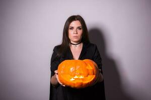 domkraft o lykta halloween pumpa flin i de mest ondska mode i kvinnas händer. foto