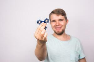 ung man spelar med en fidget spinnare, fokus på spinnare. foto