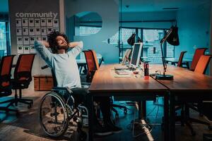 en man i en rullstol Sammanträde på en skrivbord i ett kontor foto
