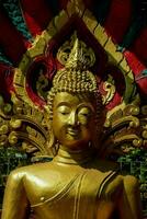 en gyllene buddha staty med en röd och guld bakgrund foto