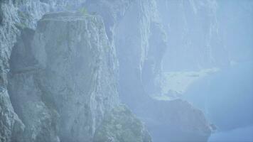 en dimmig berg landskap med en cascading vattenfall foto