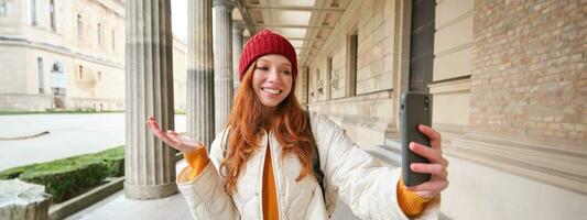 Lycklig flicka turist demonstrerar något på video chatt smartphone, visar sightseeing attraktion till vän medan på mobil telefon app ring upp foto