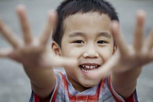 huvudskott av glad asiatisk barn ser med öga Kontakt till kamera foto