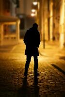 de mystisk figur av en man på en folktom gata av de gammal stad i de ljus av lyktor.selektiv fokus . hög kvalitet Foto