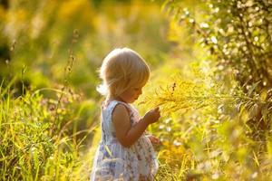 liten blond tjej i en klänning foto