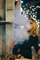kvinna röker vattenpipa i vardagsrum bar. foto