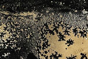 vätska konst. metallisk guld abstrakt vågor på svart bakgrund. marmor effekt bakgrund eller textur foto