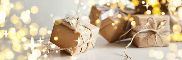 baner med gåva lådor packade i papper, dekorerad med spets och snöre. eco jul dekor foto