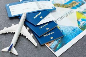 flyg biljetter med pass, modell av flygplan och Karta på grå bakgrund. foto