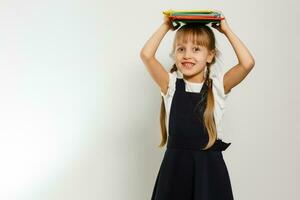 liten blond skola flicka med ryggsäck väska porträtt isolerat på vit bakgrund foto