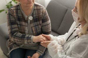 stödjande kvinna sjuksköterska besök gammal mormor patient på Hem lyssna till klagar bekymmer, uppmärksam ung kvinna läkare hört mogna senior mormor, äldre medicinsk sjukvård begrepp foto