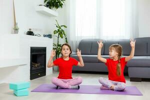 skön atletisk ung flickor praktiserande yoga tillsammans på Hem foto